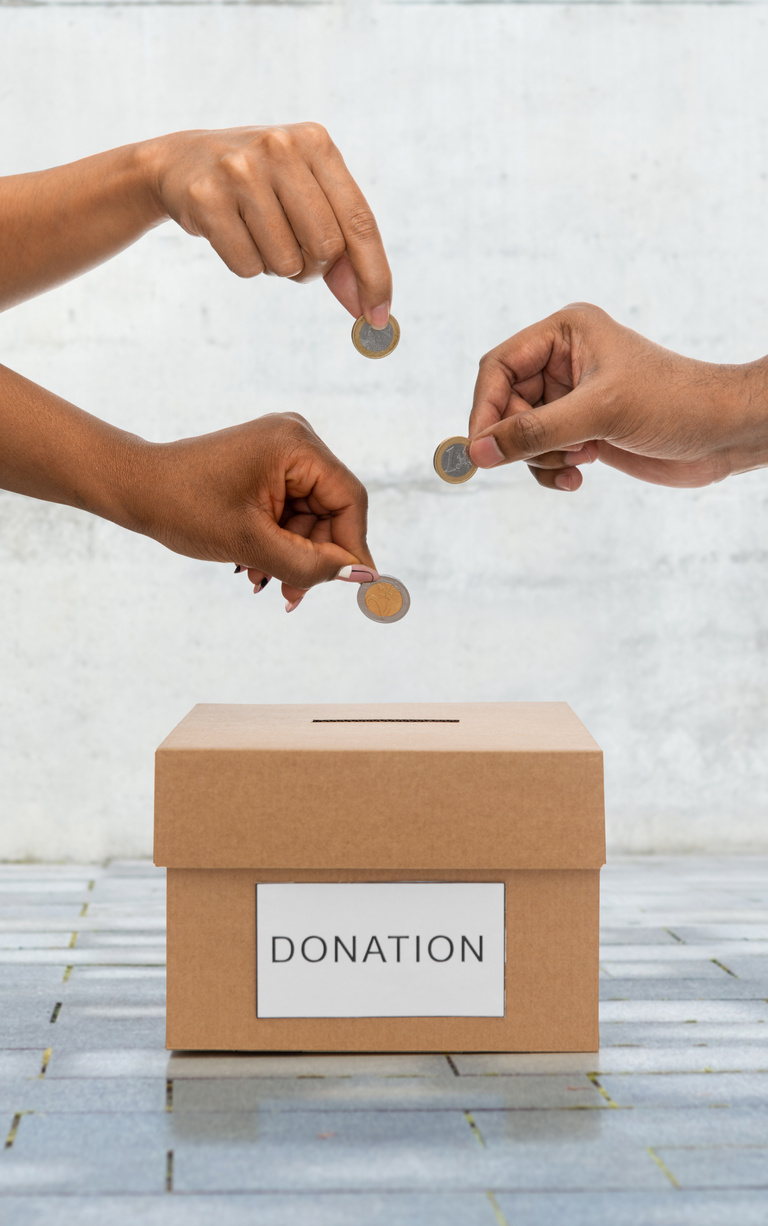 Hands Putting Coins into Donation Box on Street